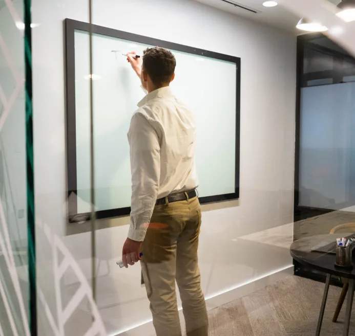 Working through a problem at a whiteboard in an office