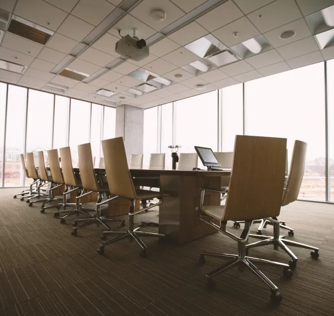 A meeting room with a long table and glass walls